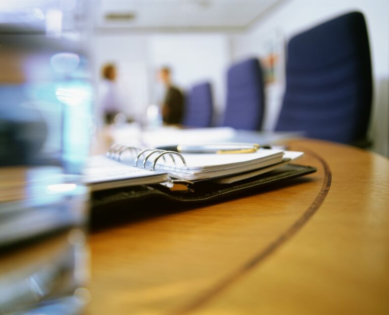 Conference room table with organiser and notes prepared for a governance decision.