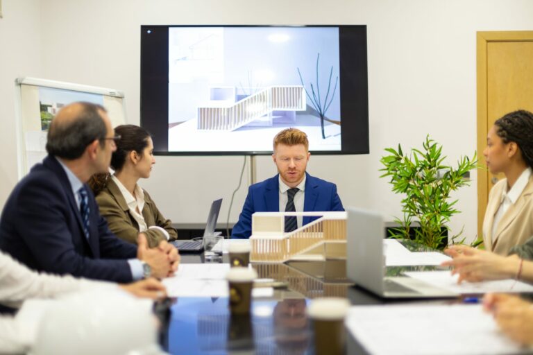 Architects and stakeholders discussing building design and smart-environment governance in a meeting room.