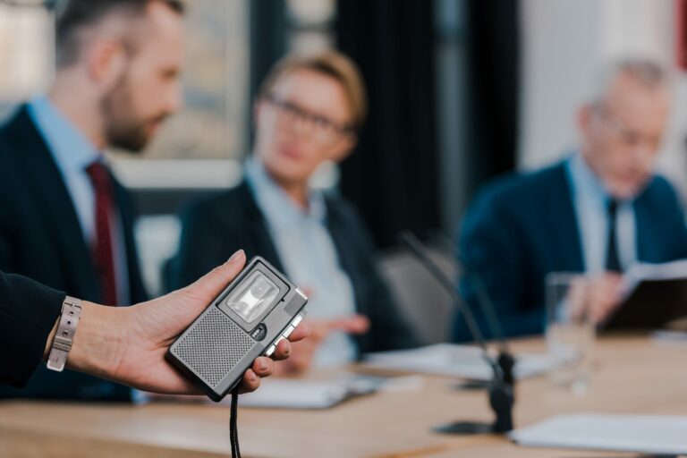 Business meeting with a recording device, illustrating privacy governance for emerging connected technologies.