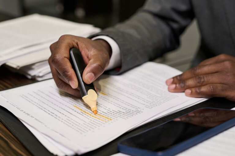 Person highlighting text in a business document during a privacy and legal review.