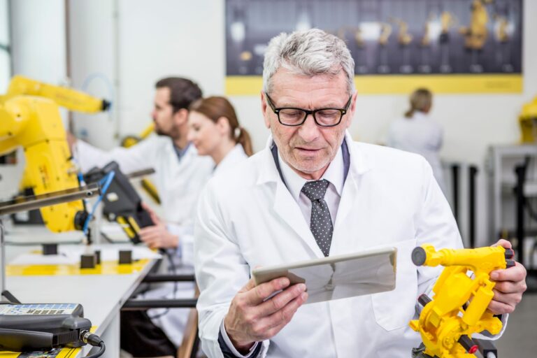 Engineers inspecting a robotic system and reviewing evidence on a tablet