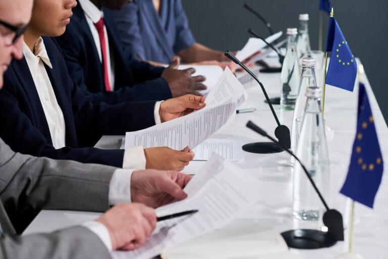 Officials reviewing documents during a European regulatory meeting